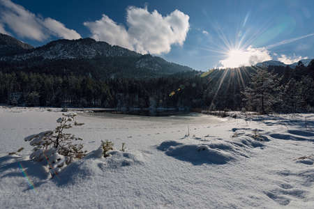 idyllic winter landcape at small lake and powder snowの写真素材