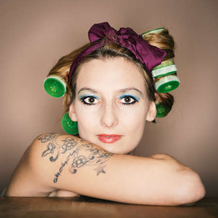 young girl with tattoo on arm and hair roller