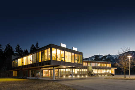 illuminated modern wooden office building at nightの写真素材