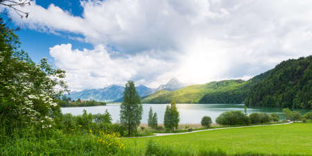 lake weissensee in bavaira with sun coming out through cloudsの写真素材