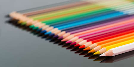 arranged colored wood pencils lying on black backgroundの写真素材
