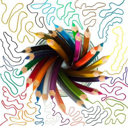 bunch of wooden color pencils in a glass with colored sketch linesの写真素材