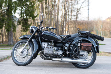 sideview of black oldtimer motorbike with sidecar an leather bagの写真素材
