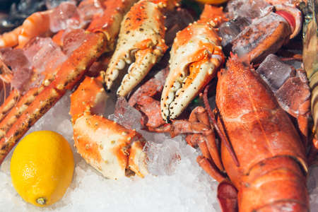 fresh frozen lobster on ice with lemon at marketの写真素材