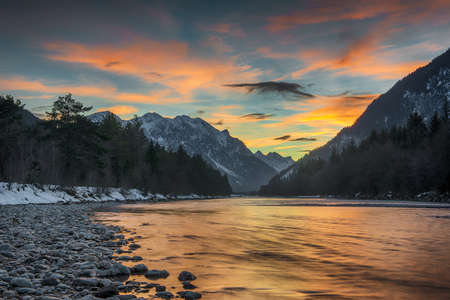 wild alpine river lech at sunset between alpine mountainsの写真素材