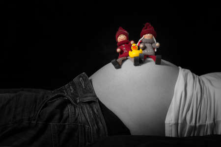 parent dolls and baby duck sitting on pregnant belly of motherの写真素材