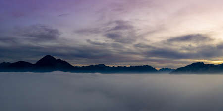 view over cloud bank to mountains of reutte valley at sunset dawnの写真素材