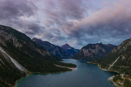 aerial view of dramatic cloudy sky over lake plansee at fallの写真素材