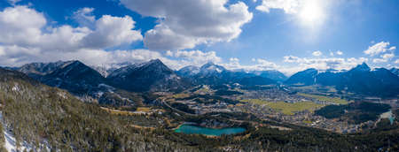 Panorama of circular deep valley basin of Reutte and Breitenwang with lake Urisee at sunny spring dayの写真素材