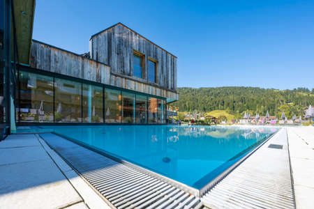 wellness window glass-fronted building with vertically planked old wood in the midst of green natureの写真素材