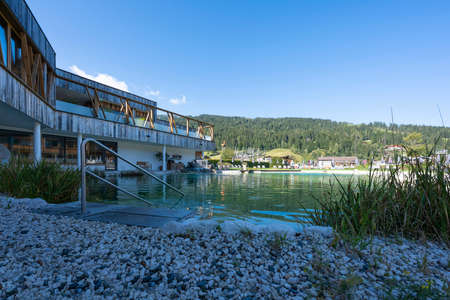 natural pond near a modern building with old wood and beautiful green nature in autumnの写真素材