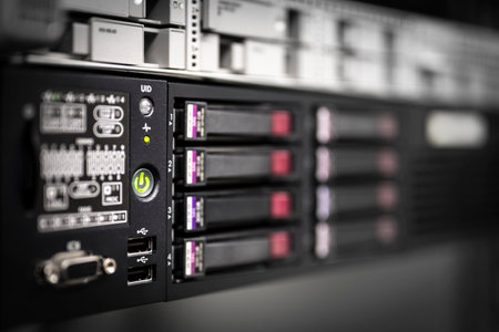 oblique view of the front of a server with hard drive trays with depth of field blur