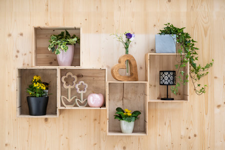self-made wall decoration with old wine crates as a flower shelf on spruce boardの写真素材
