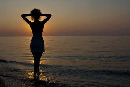 The siluette of young women against a background of sunriseの写真素材