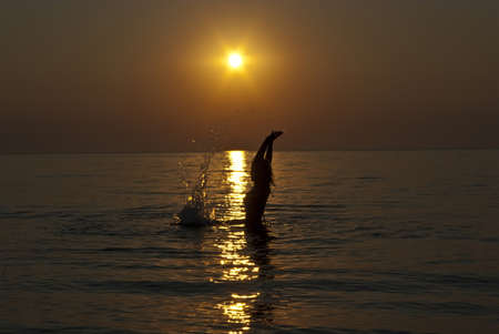 The siluette of young women against a background of sunriseの写真素材