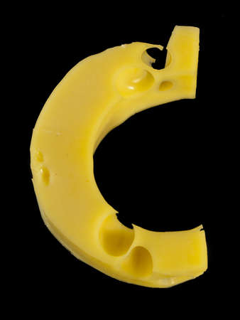 Letter C from cheese piece isolated on blackの写真素材