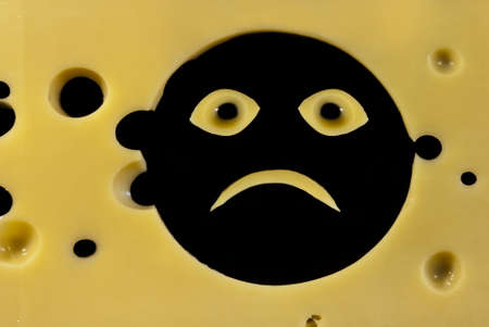 Smile face made from sliced cheese on blackの写真素材