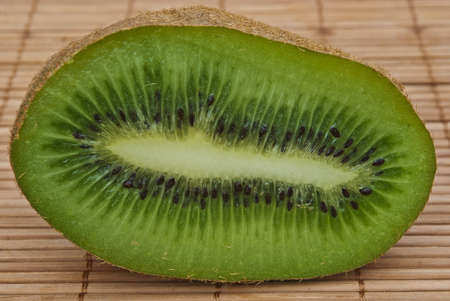 One half of sliced kiwi on wood backgroundの写真素材