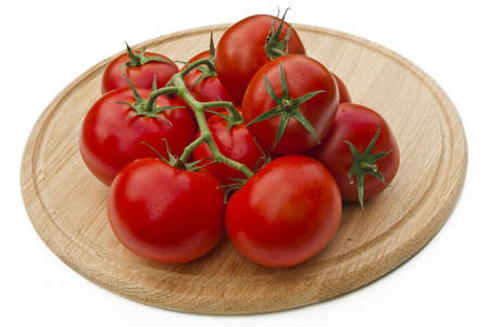 Tomatoes on a cutting board isolated over whiteの写真素材