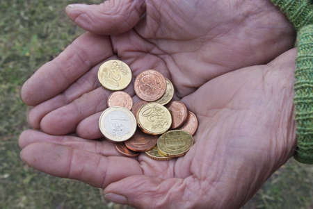 Euro coins in hands of adult womanの写真素材