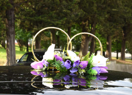 Wedding car with rings and flowersの写真素材