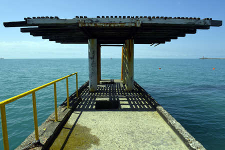Concrete pier with a blue wavy sea. Calm sea water.の写真素材