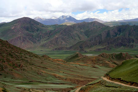 Green tibetan landscape on the road from Saga, Central Tibetの写真素材