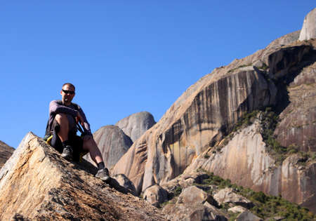 Man sitting on the rocky edge in Anja Reserve in Madagascarの写真素材