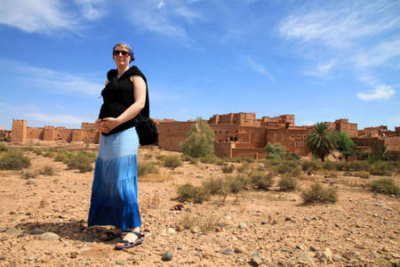 Pregnant woman tourist in front of Kasbah in Ouarzazate, Moroccoの写真素材
