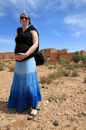 Pregnant woman tourist in front of Kasbah in Ouarzazate, Moroccoの写真素材