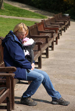 Mother carrying Her daughter In a baby carrierの写真素材