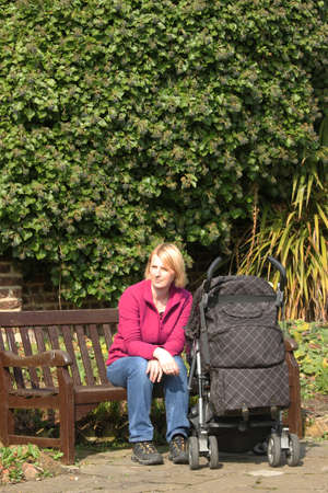 Mother with her child in a pram in the parkの写真素材