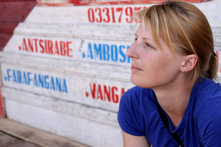 Girl waiting for a taxi or brousse   minivan   on the small terminal in Madagascarの写真素材