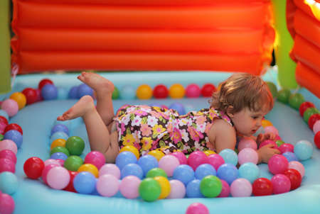 Little girl surrounded by colourful ballsの写真素材