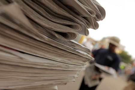 Pile of newspapers on a stand, ready to be distributedの写真素材