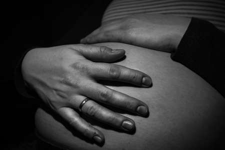 Pregnant woman holding her hand on her belly as she is expecting a boy soonの写真素材