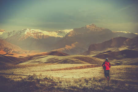 Woman running towards the beautiful Alamut mountains in the northern Iran in winter