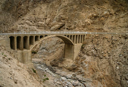 Bridge on the remote mountain road in Karakorum, Pakistanの写真素材