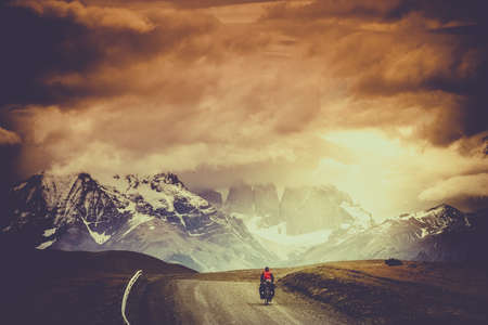 Woman cycling on a difficult mountain road towards Shandur Pass in northern Pakistanの写真素材