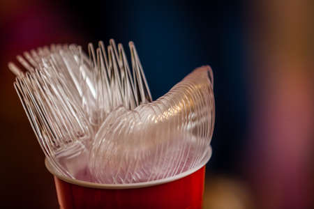 Plastic forks and spoons in a cupの写真素材