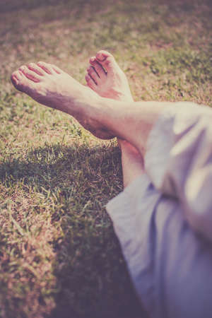 Men s feet on the grass in the park in summerの写真素材