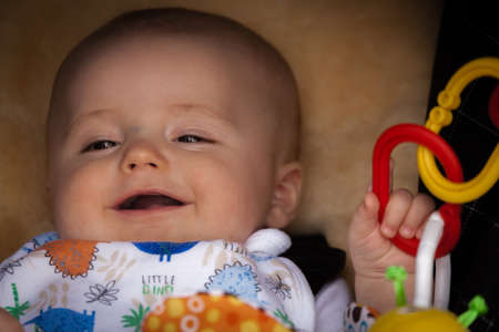 Portrait of a happy and adorable baby boy 3 months old in his pushchair