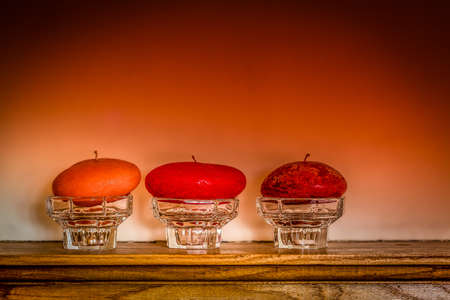 Three candles standing on a wooden panel above fireplaceの写真素材