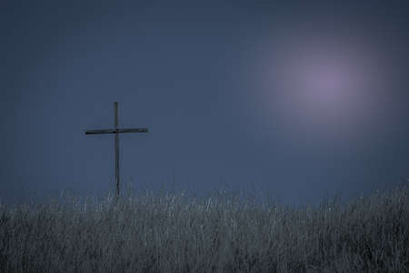 Lonely cross in the field in the countryside at nightの写真素材