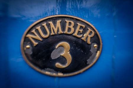 Old door plaque with the number 3 written on itの写真素材