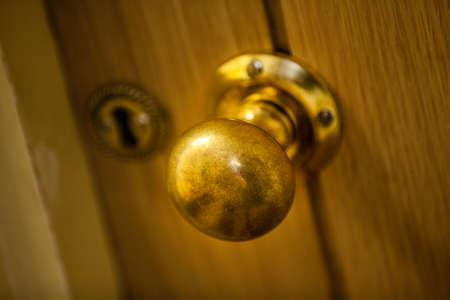 Golden door knob on wooden doors insideの写真素材