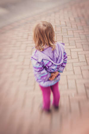 Little baby girl waiting for her mum outside her nurseryの写真素材