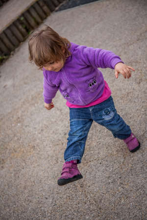 Little girl after kicking the ball while playing in the playground