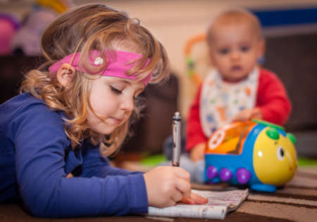 Little girl solving a crossword, kids playing at homeの写真素材