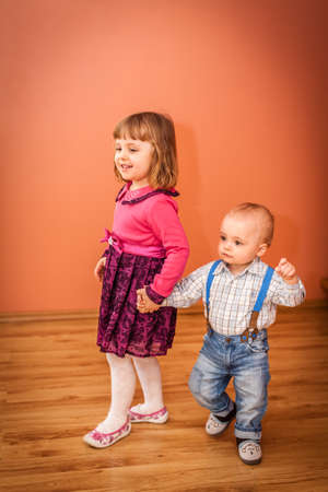 Little kids  brother and sister playing together in the living room at homeの写真素材
